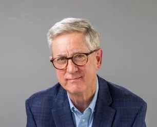 Headshot of Clancy DuBos, a grey haired white man wearing glasses