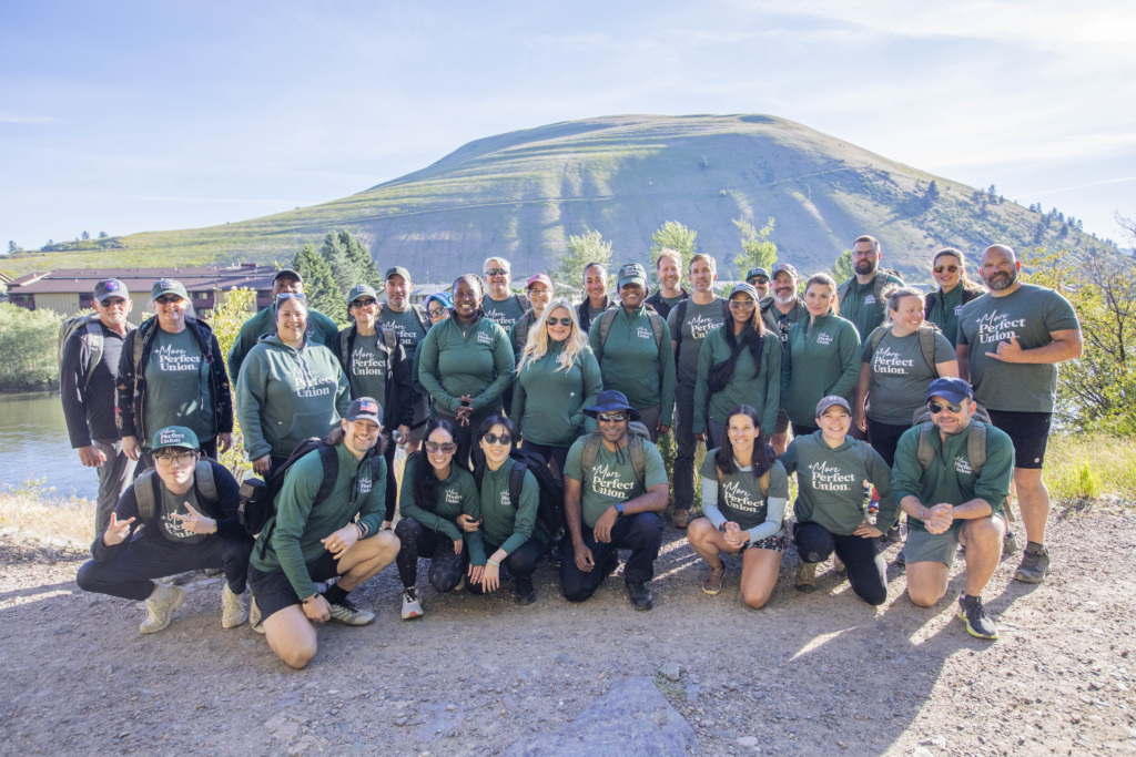 Group of 30 Americans of different backgrounds hiking in Montana wearing +MPU tshirts.